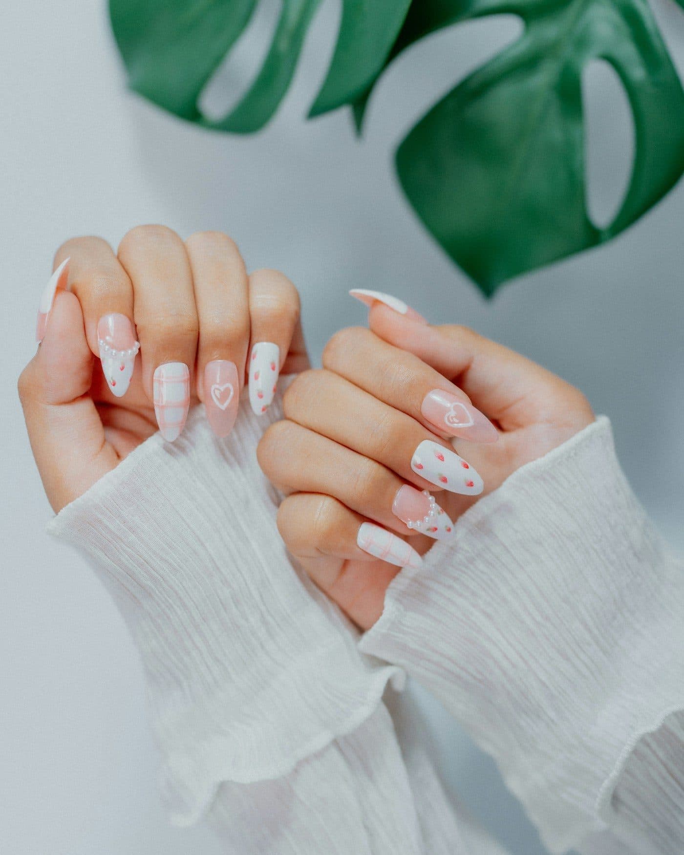 Manos con uñas decoradas con corazones